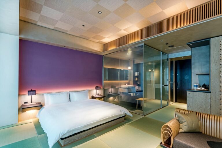 Spacious and luxurious bedroom featuring a glass wall design, blending modern aesthetics with comfort.